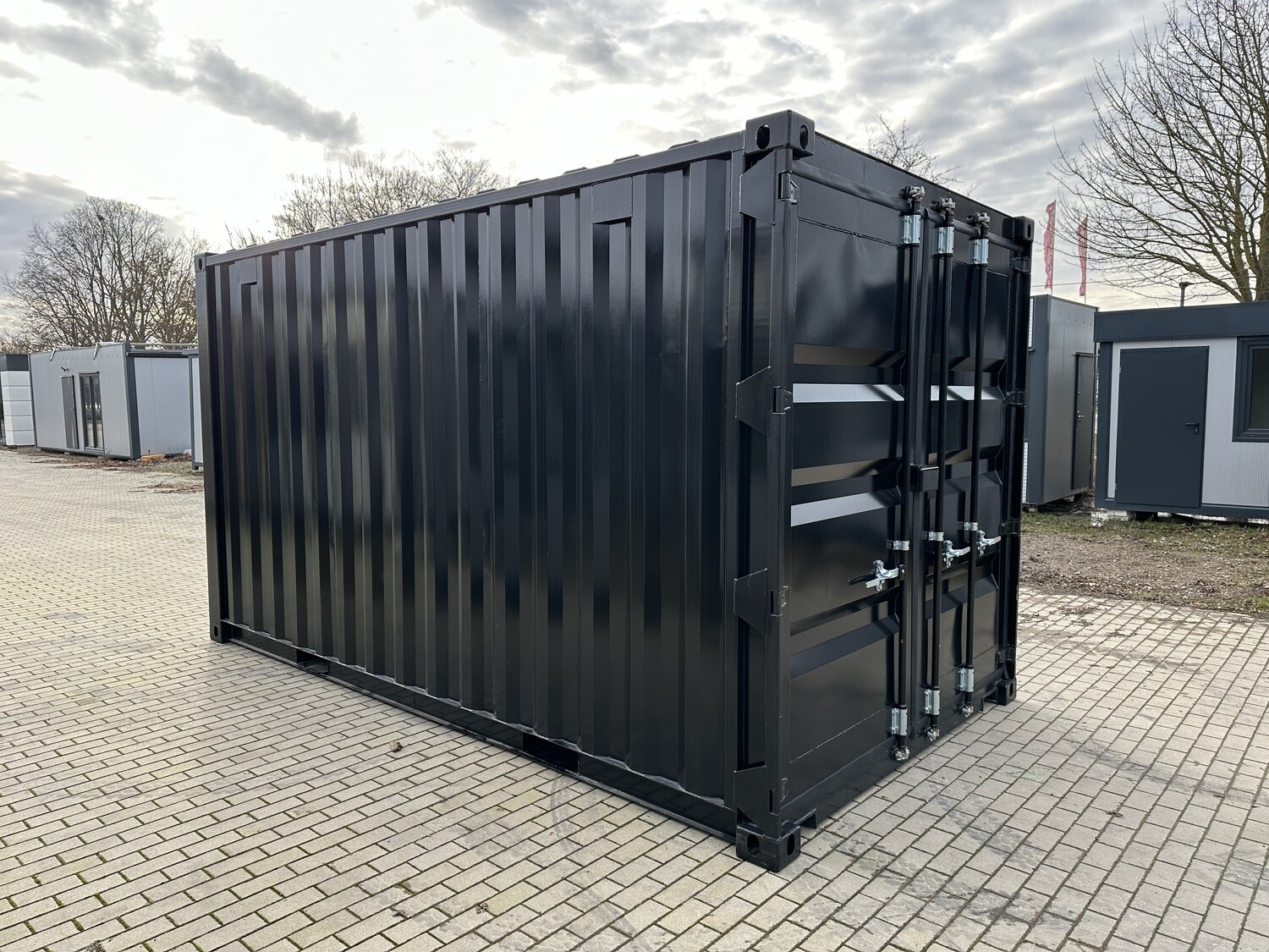 Seitliche Außenansicht des Lagercontainers: Wellblechprofil der Längsseite, rechts die Türseite mit Stangenverschluss