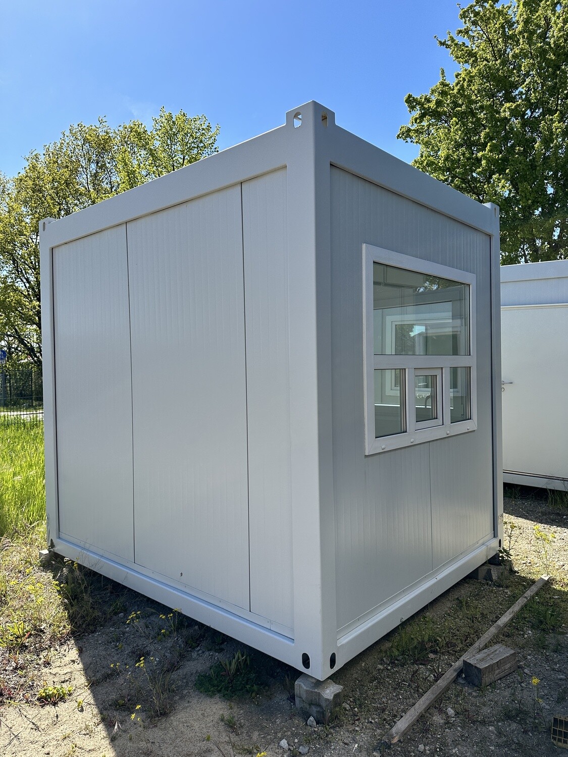 Rückseitige Ansicht des Pförtnerhauses mit geschlossener Wand und einem Fenster mit Lüftungsflügeln