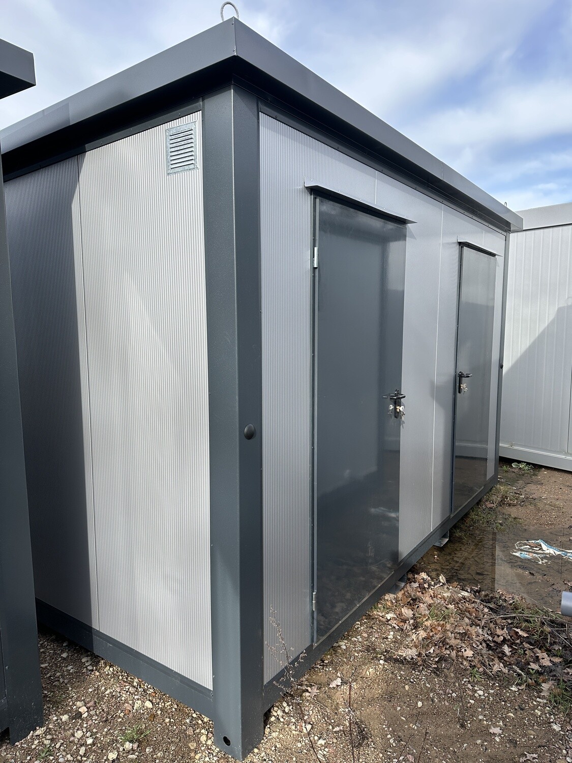 Der 4,00 x 2,00 m Duschcontainer über Eck: silbergraue Paneele, zwei Türen, Wandlüftungsgitter