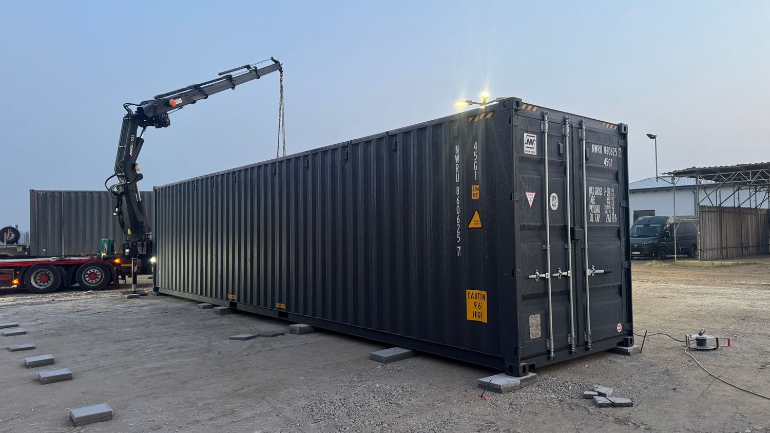 Absetzen des 12,00 x 2,44 m Seecontainers per Ladekran, Stirnseite mit verriegelten Doppeltüren