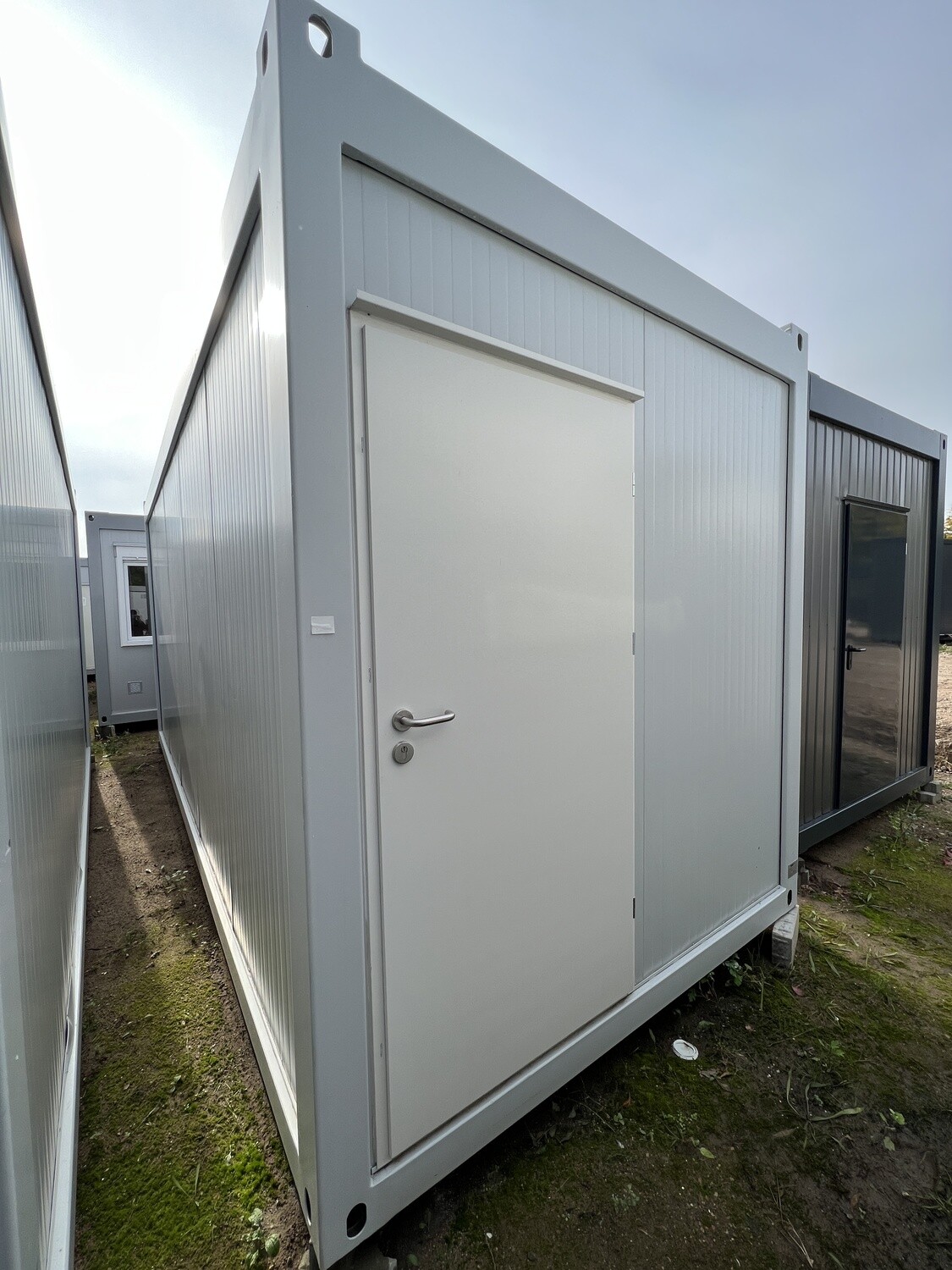 Außenansicht des Duschcontainers RAL9010 mit Tür in der Stirnwand und Stapelecken am Rahmen