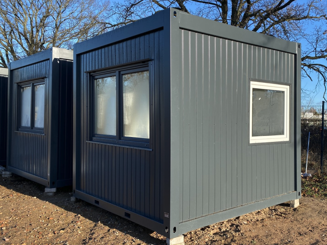 Seitliche Aufstellung des Bürocontainers 3,00 x 3,00 m mit Doppelfenster und kleinem Stirnwandfenster