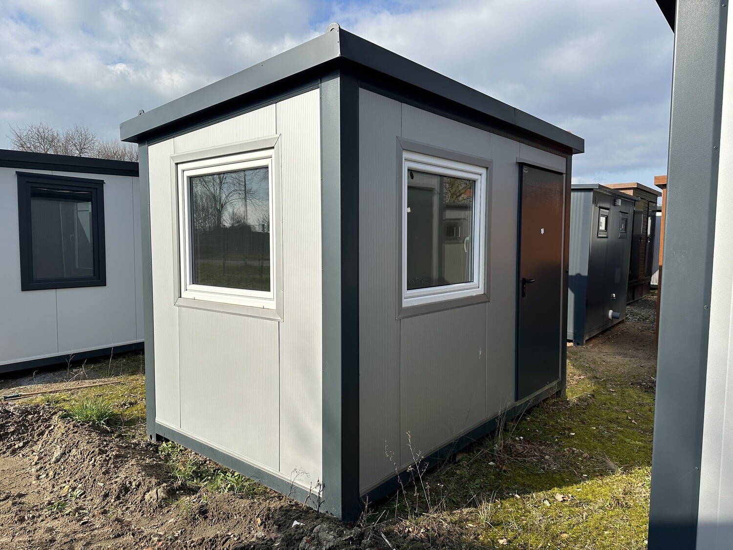 Eckansicht mit zwei Fenstern und dunkler Außentür, Bürocontainer 3,50 x 2,20 m auf Grasfläche