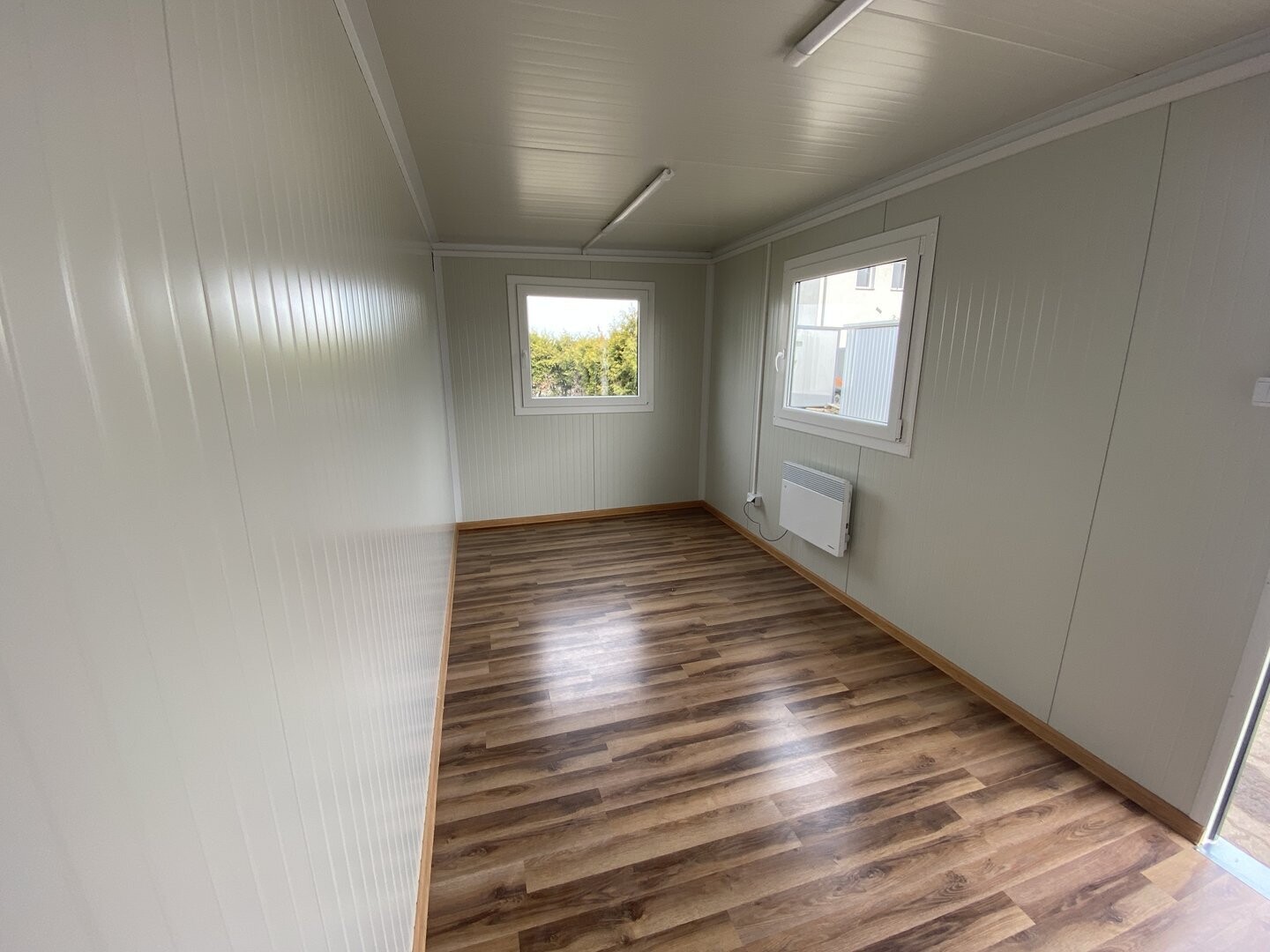 Längsblick durch den Bürocontainer 5,00 x 2,40 m mit zwei Fenstern, Deckenleuchten und Heizkörper