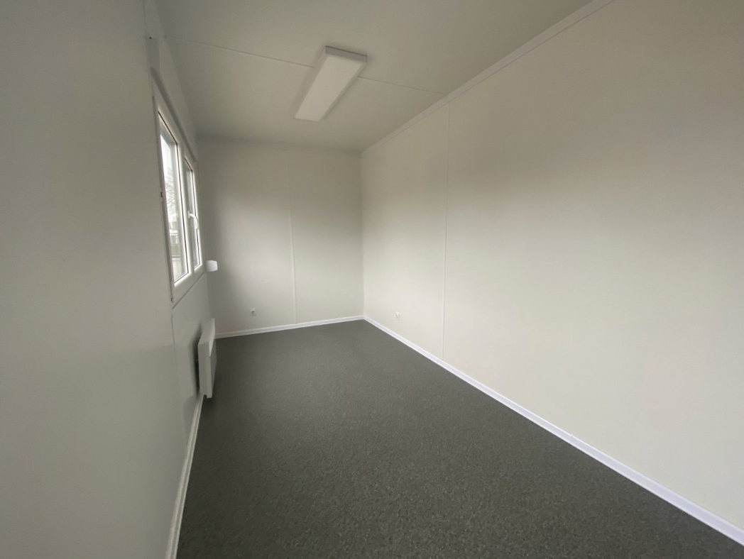 Deckenleuchte, Fenster und Heizgerät über grauem Bodenbelag im Bürocontainer 6,00 x 2,44