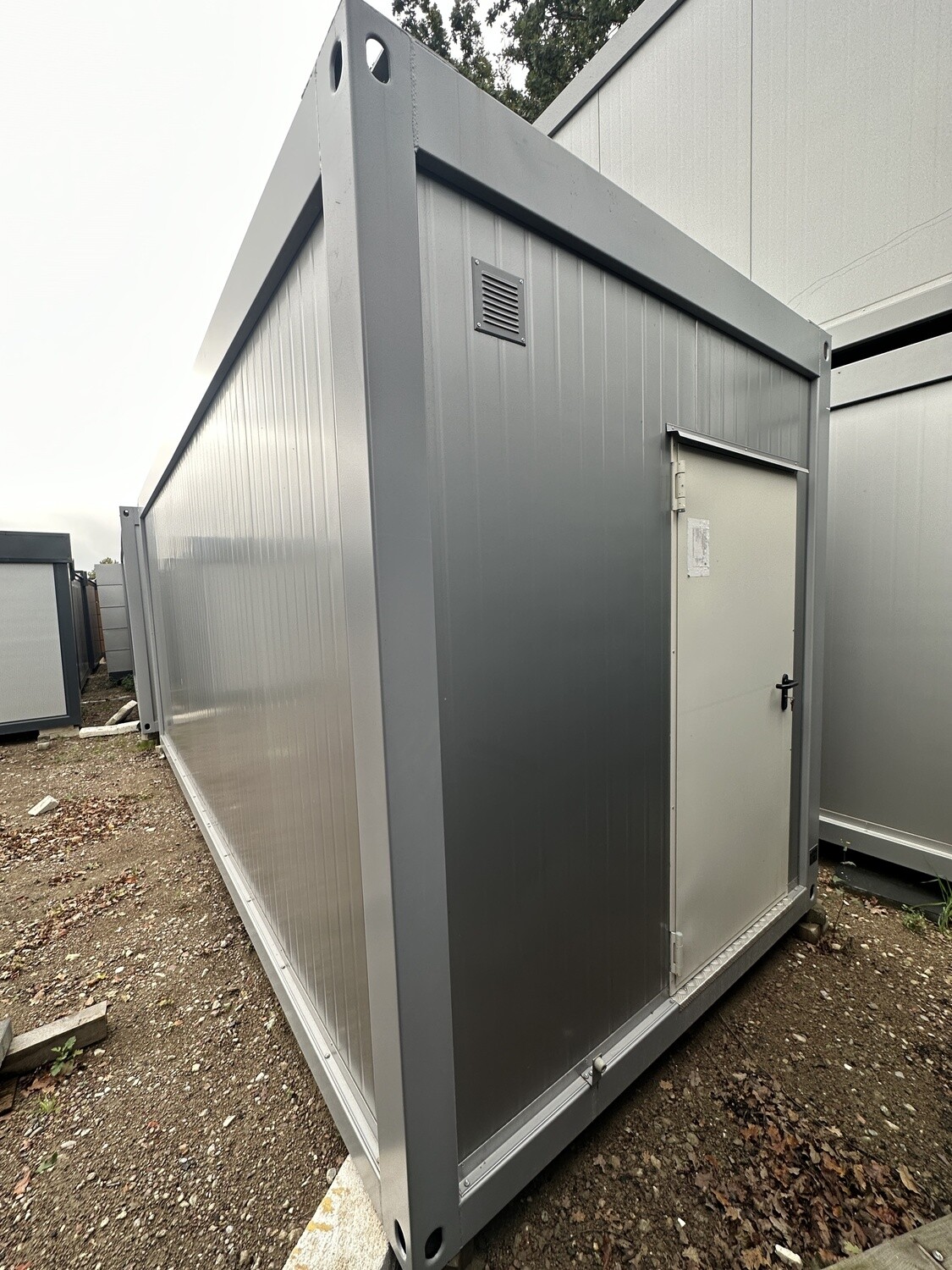 Stirnseite mit Eingangstür, Lüftungsgitter und Stapelecken am Bürocontainer 6,00 x 2,44