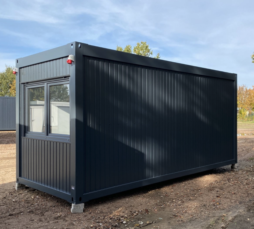 Seitenansicht des Bürocontainers: lange geschlossene Wandfläche, stirnseitig ein Fenster mit Rollladen