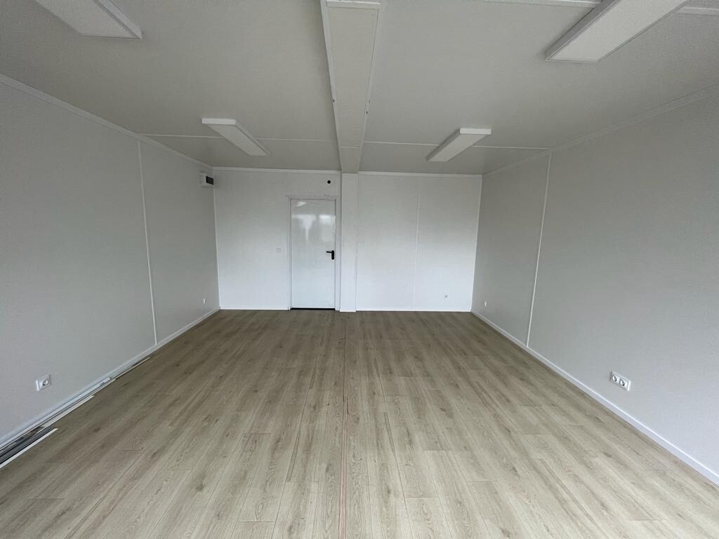Heller Dielenboden und weiße Innentür in der Trennwand, LED-Leuchten an der Decke des Doppelcontainers