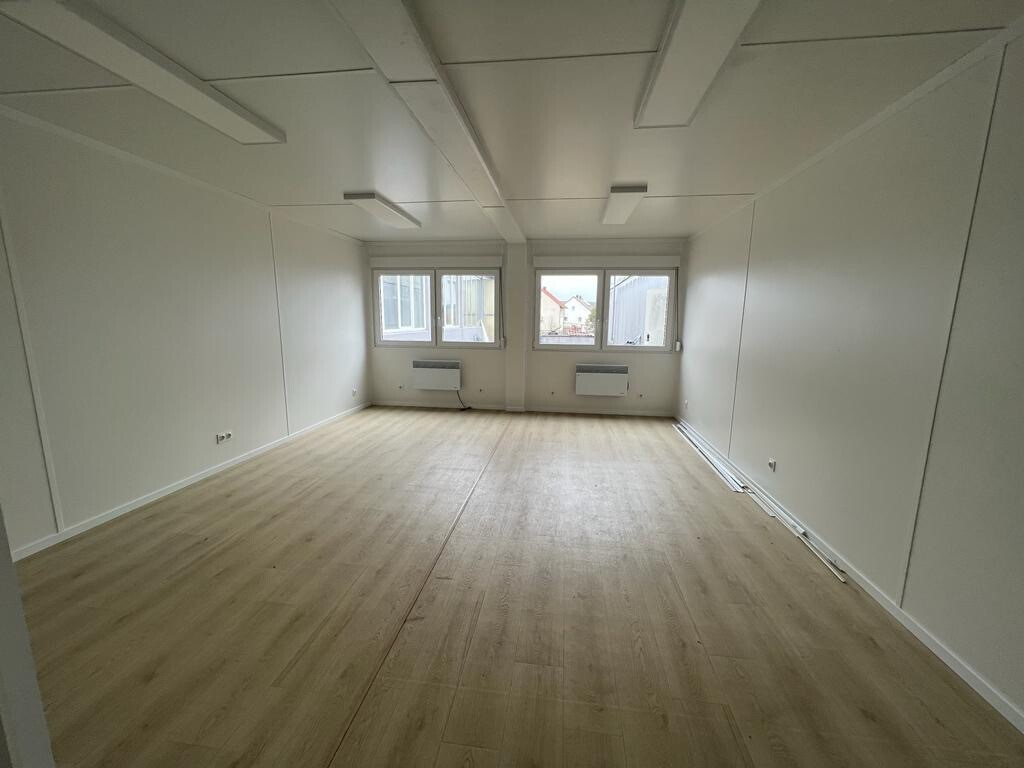 Stirnwand mit zwei Fenstern und Wandkonvektoren über hellem Dielenboden im Doppelcontainer