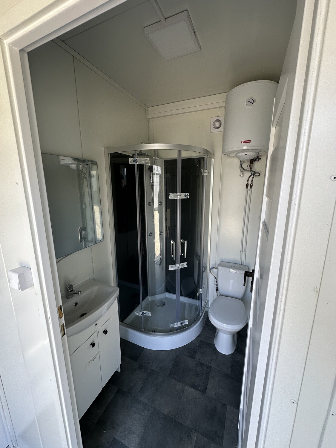 Duschbad der Tromsø mit Eckduschkabine, Waschtisch samt Spiegel, WC und Warmwasserspeicher