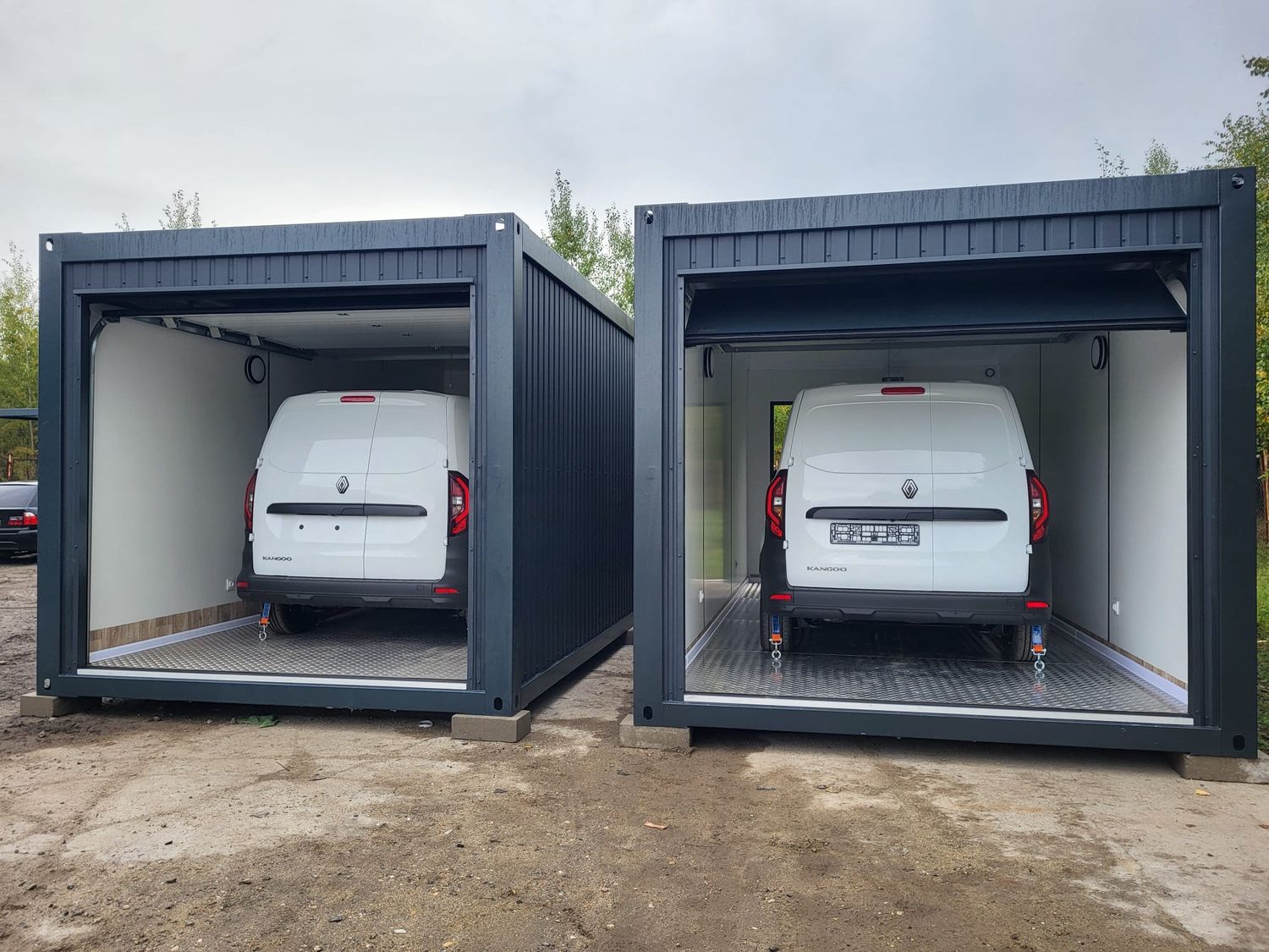 Zwei nebeneinander aufgestellte Garagencontainer mit offenen Toren und je einem Kastenwagen