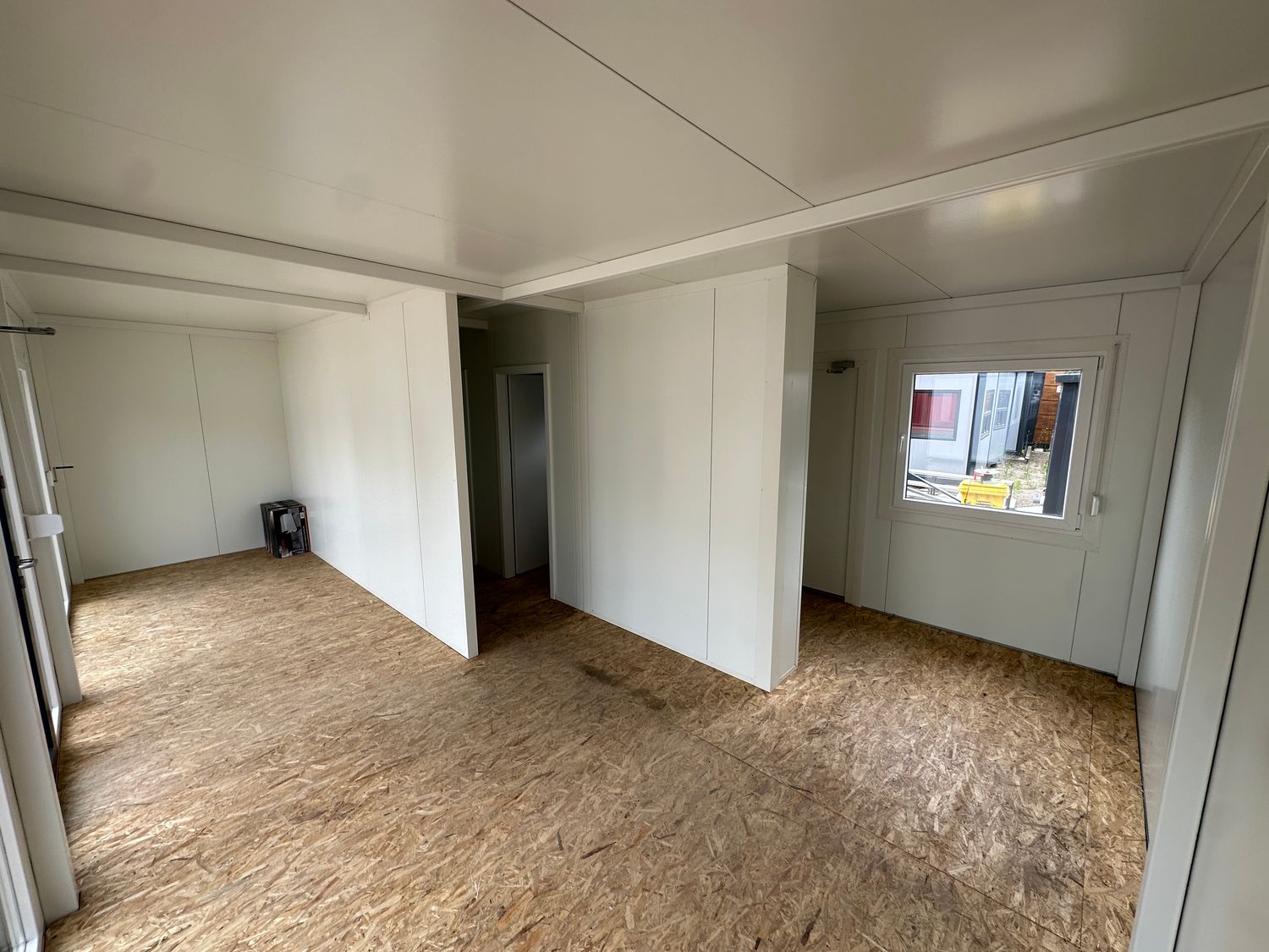 Leerer Innenraum mit Trennwänden, kleinem Kippfenster und OSB-Boden im Imbisscontainer 5,00 x 8,00