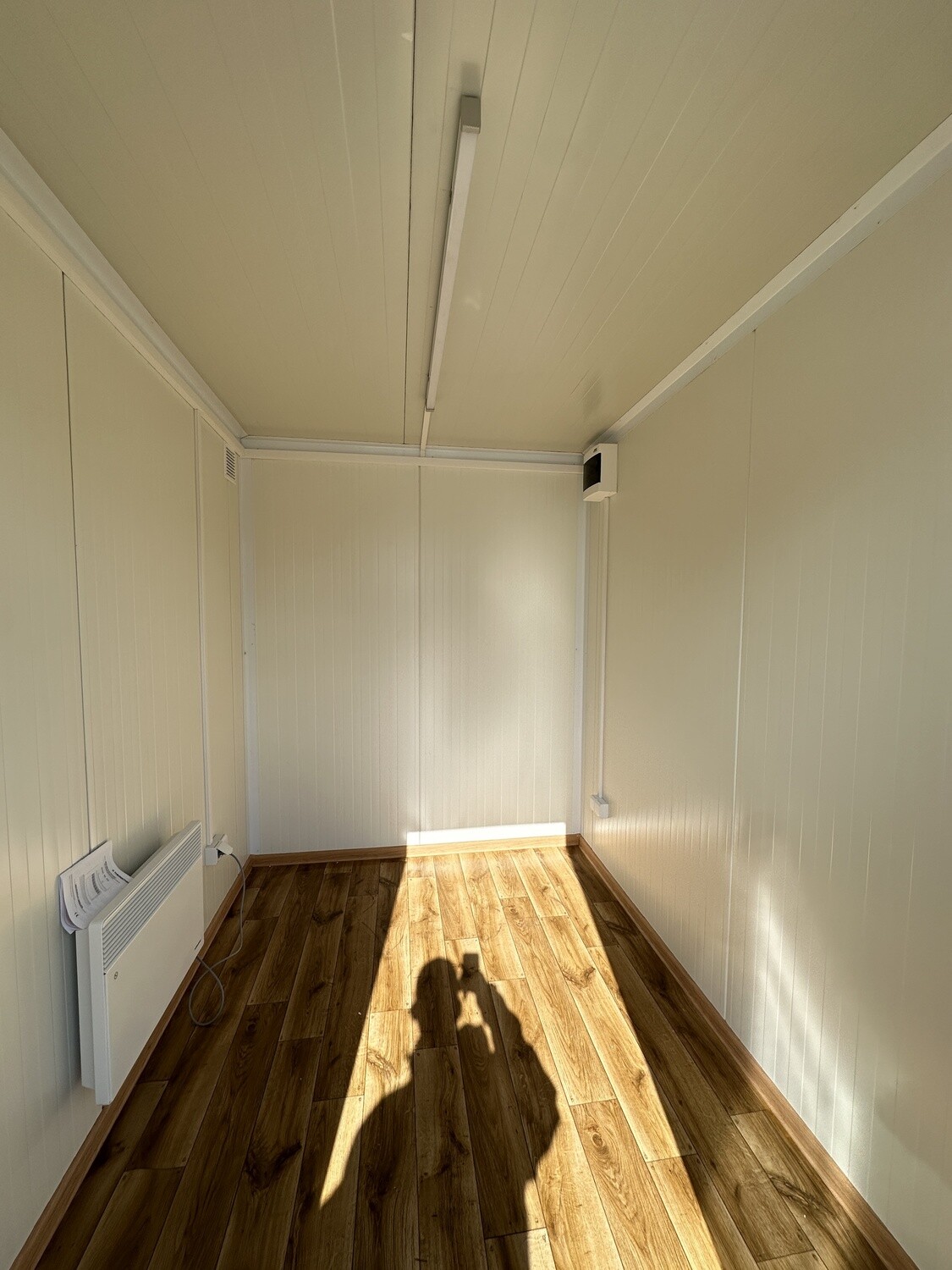 Innenraum mit Holzdekor-Boden, Wandkonvektor und Deckenleuchte im Lagercontainer 2,60 x 2,00 m