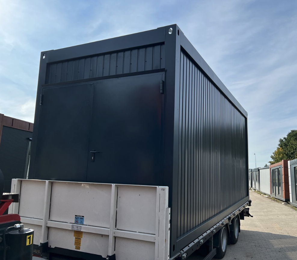 Auf einem Anhänger stehender dunkler Lagercontainer mit geschlossener zweiflügeliger Tür