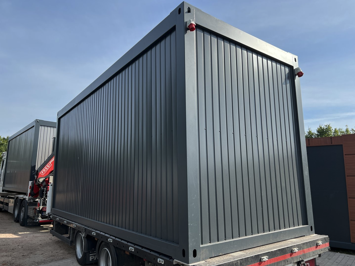 Rückansicht des grauen Lagercontainers auf dem Anhänger, mit Stapelecken an den Dachkanten