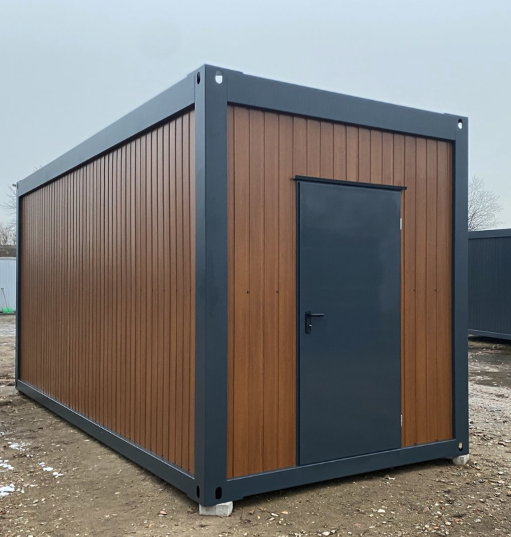 Stirnseite mit dunkler Eingangstür, seitlich schließt die lange Wand in Holzoptik an