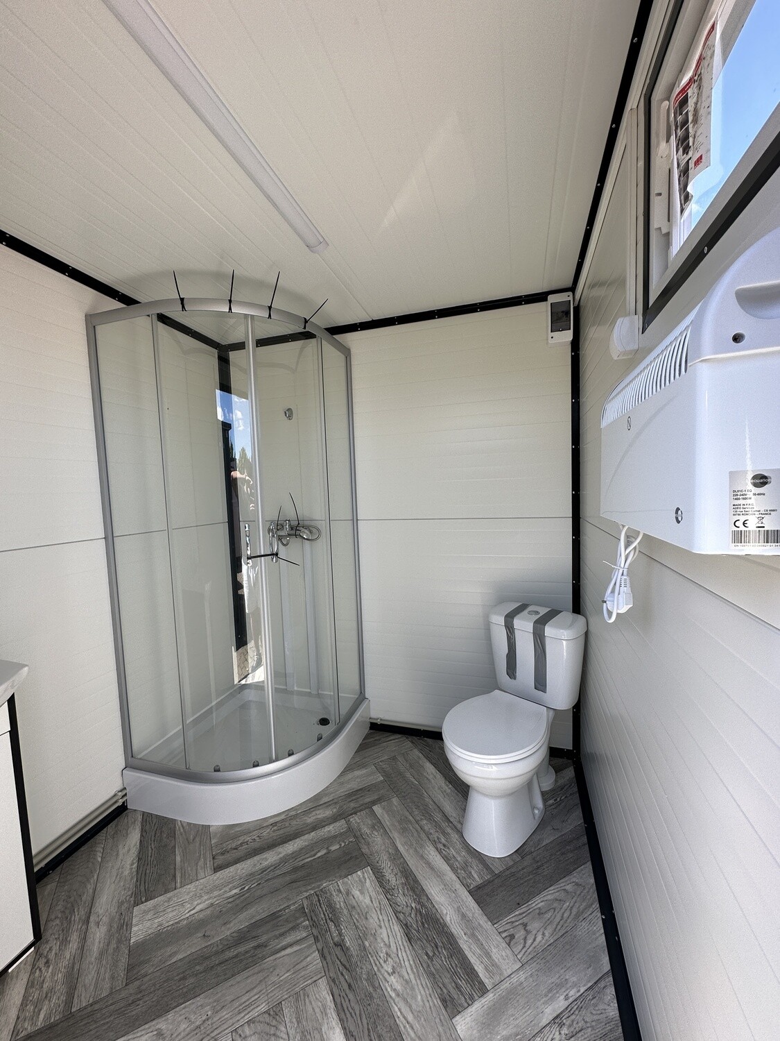 Innenansicht mit Rundduschkabine, WC und Wandheizgerät im Sanitärcontainer 2,00 x 2,00 m
