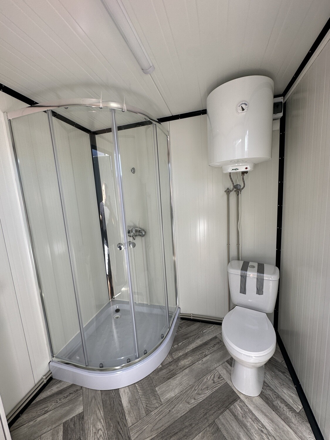 Duschkabine, WC und wandhängender Boiler im Innenraum des Sanitärcontainers 2,00 x 2,00 m
