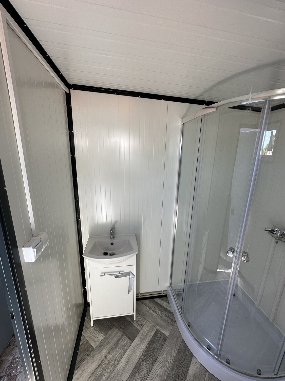 Waschtisch mit Unterschrank und Rundduschkabine innen im Sanitärcontainer 2,00 x 2,00 m