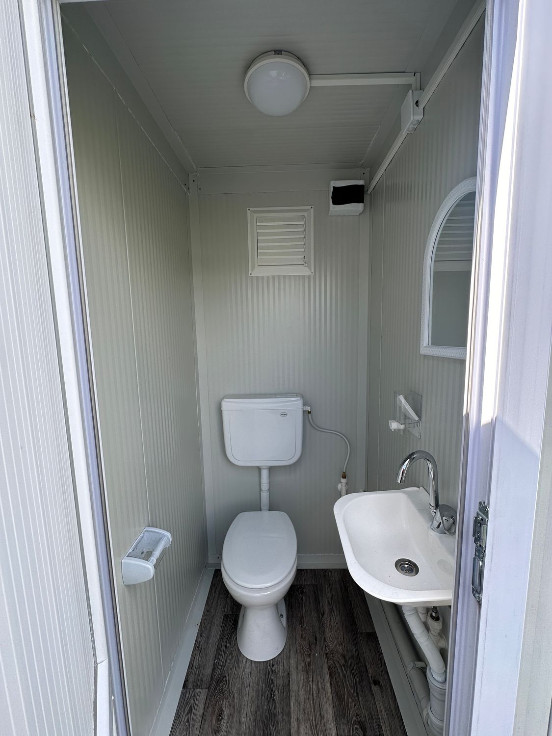 Zweite Kabine des Doppel-WC 2,20 x 1,30 m mit WC, Waschbecken, Spiegel und Deckenleuchte
