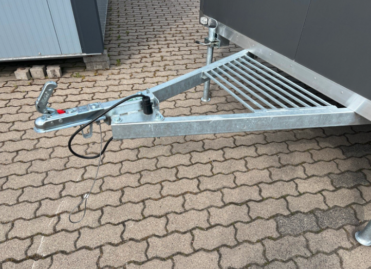 Detailaufnahme der verzinkten Deichsel mit Kupplung, Stützrad und geripptem Trittblech