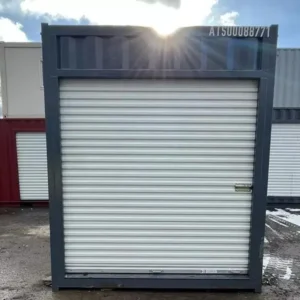 Stirnseite des 10-Fuß-High-Cube-Containers mit weißem Rolltor, aufgestellt auf einem Containerplatz