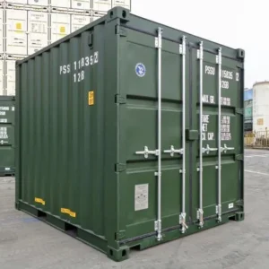 Dunkelgrüner 10-Fuß-Seecontainer schräg von vorn auf dem Lagerplatz, gestapelte Container dahinter