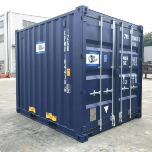 Dunkelblauer 10-Fuß-Standardcontainer im Halbprofil mit verriegelten Doppeltüren vor einer Werkhalle