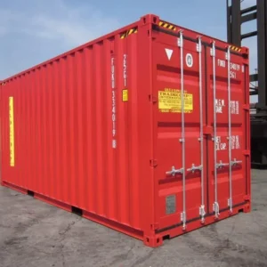 Roter 20-Fuß-High-Cube-Seecontainer schräg von der Türseite, dahinter ein Stapler im Hafen
