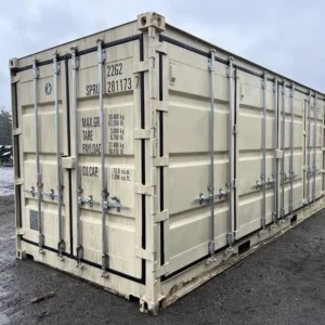 Eckansicht des 20-Fuß-Lagercontainers Open Side mit geschlossenen Stirn- und Seitentüren auf nassem Schotter