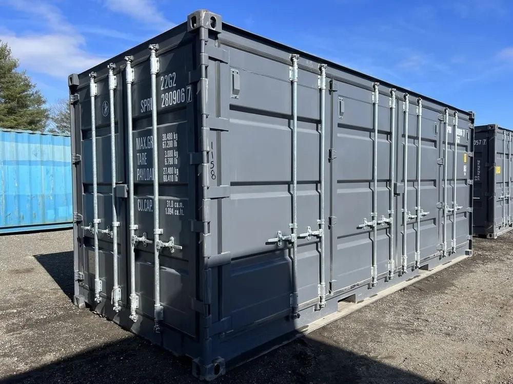 Grauer 20-Fuß-Lagercontainer mit durchgehenden Seitentüren und hellen Verschlussstangen im Hof
