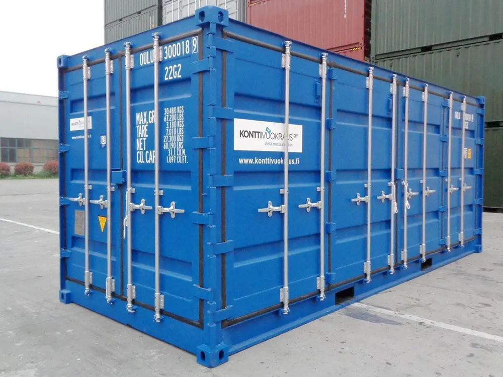 Blauer Open-Side-Container mit Firmenaufkleber auf der Seitenwand, abgestellt auf asphaltiertem Platz