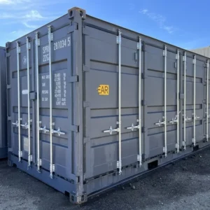 Schrägansicht des grauen 20-Fuß-Open-Side-Lagercontainers mit geschlossenen Seitentüren auf Schotterplatz