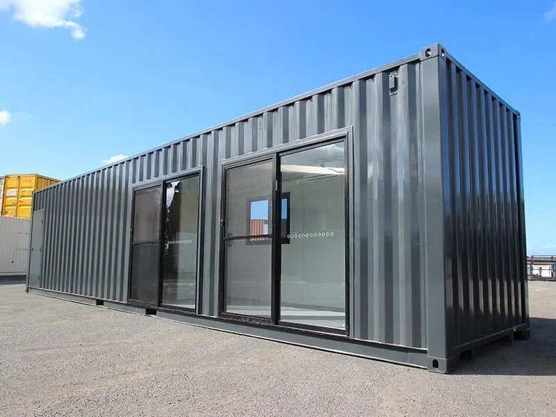 Dunkelgraue Längsseite des 40-Fuß-Bürocontainers mit zwei großen Glas-Schiebetüren und Blick ins Innere
