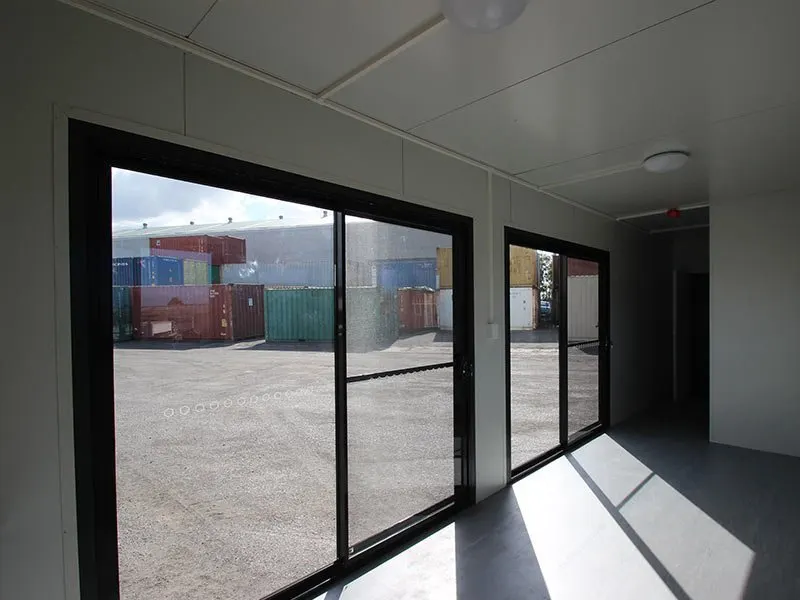 Von innen zeigen die raumhohen Schiebetüren den Containerhof, an der Decke sitzen zwei Leuchten