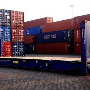 Blauer 40-Fuß-Flatrack-Container mit Sonderfertigung, offene Ladefläche und Stirnwand vor Containerstapeln
