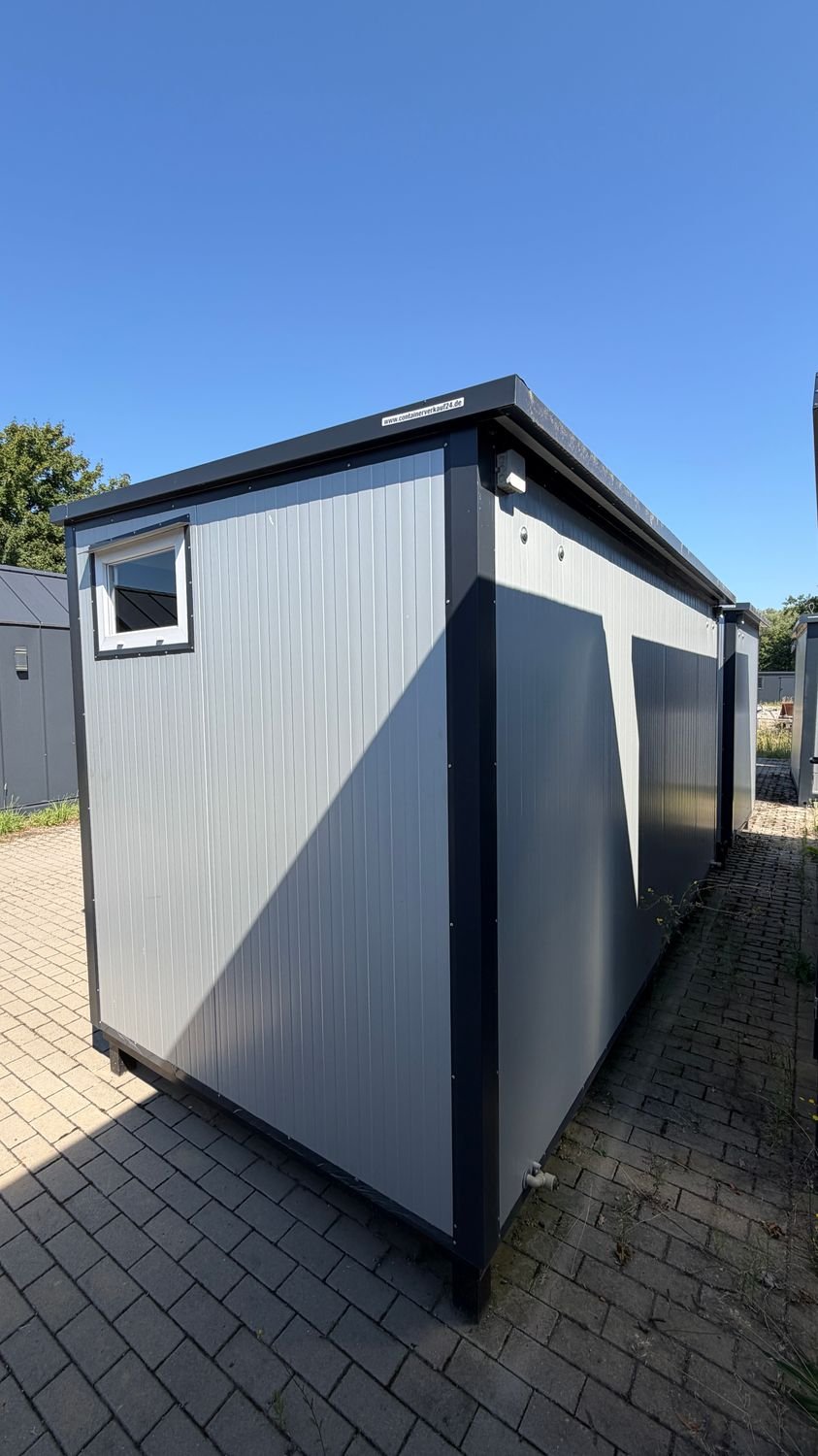 Rückwärtige Seitenansicht mit Kippfenster, Außenleuchte am Dachrand und Abwasseranschluss unter dem Rahmen
