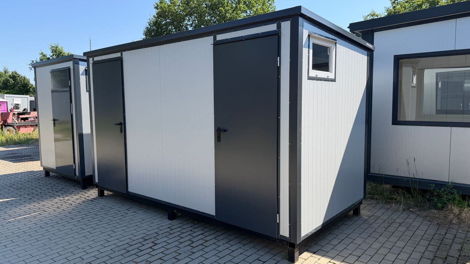 Außenansicht des 4,00 x 2,00 m Doppel-WC- und Duschcontainers mit zwei anthrazitfarbenen Türen und Eckfenster