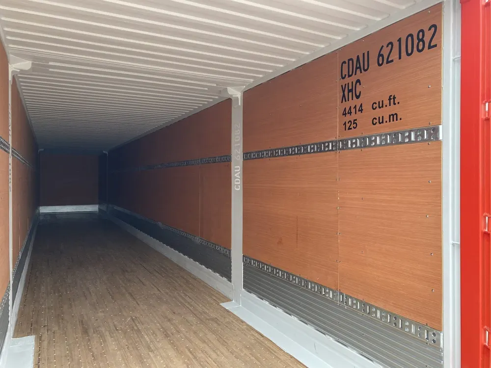 Innenansicht mit Holzboden, heller Decke und umlaufenden Zurrschienen entlang der Seitenwand