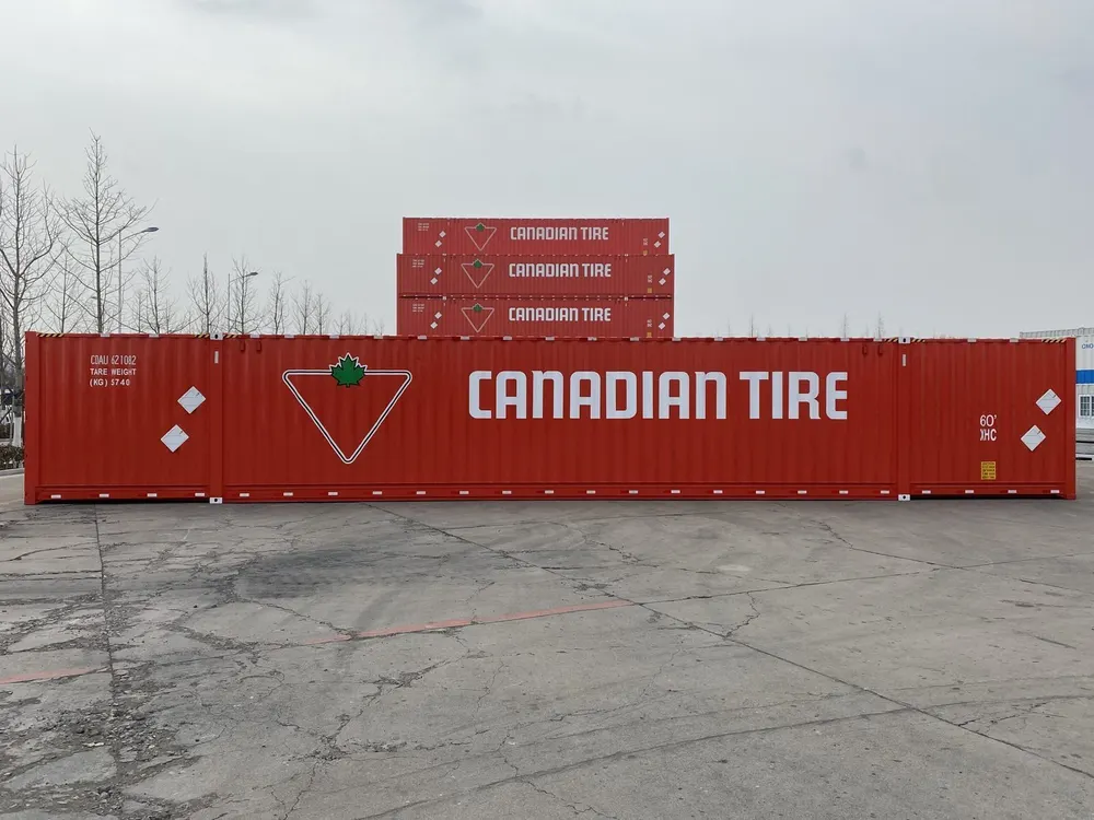 Seitenansicht des roten 60-Fuß-Seecontainers mit Canadian-Tire-Schriftzug, dahinter gestapelte Einheiten