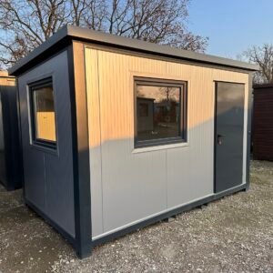 Hell verkleideter Bürocontainer 4,00 x 2,20 m mit dunklem Rahmen, Fenster und Tür auf Kiesfläche