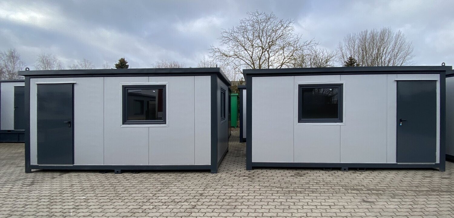 Zwei hell verkleidete Bürocontainer 5,00 x 2,40 m nebeneinander, je mit Tür und Fenster im Hof