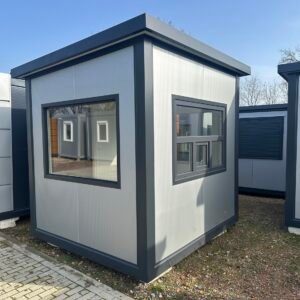 Pförtnerhaus in Hellgrau mit anthrazitfarbenen Kanten, großer Fensterfront und seitlichem Fenster