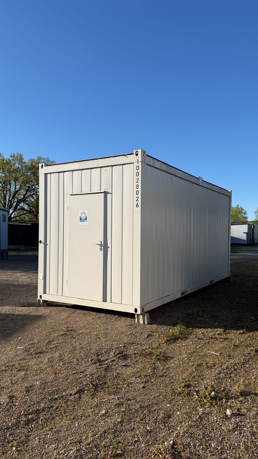 Türseite des 20’ Containers mit Stapelecken, auf Kanthölzern im Freien aufgestellt