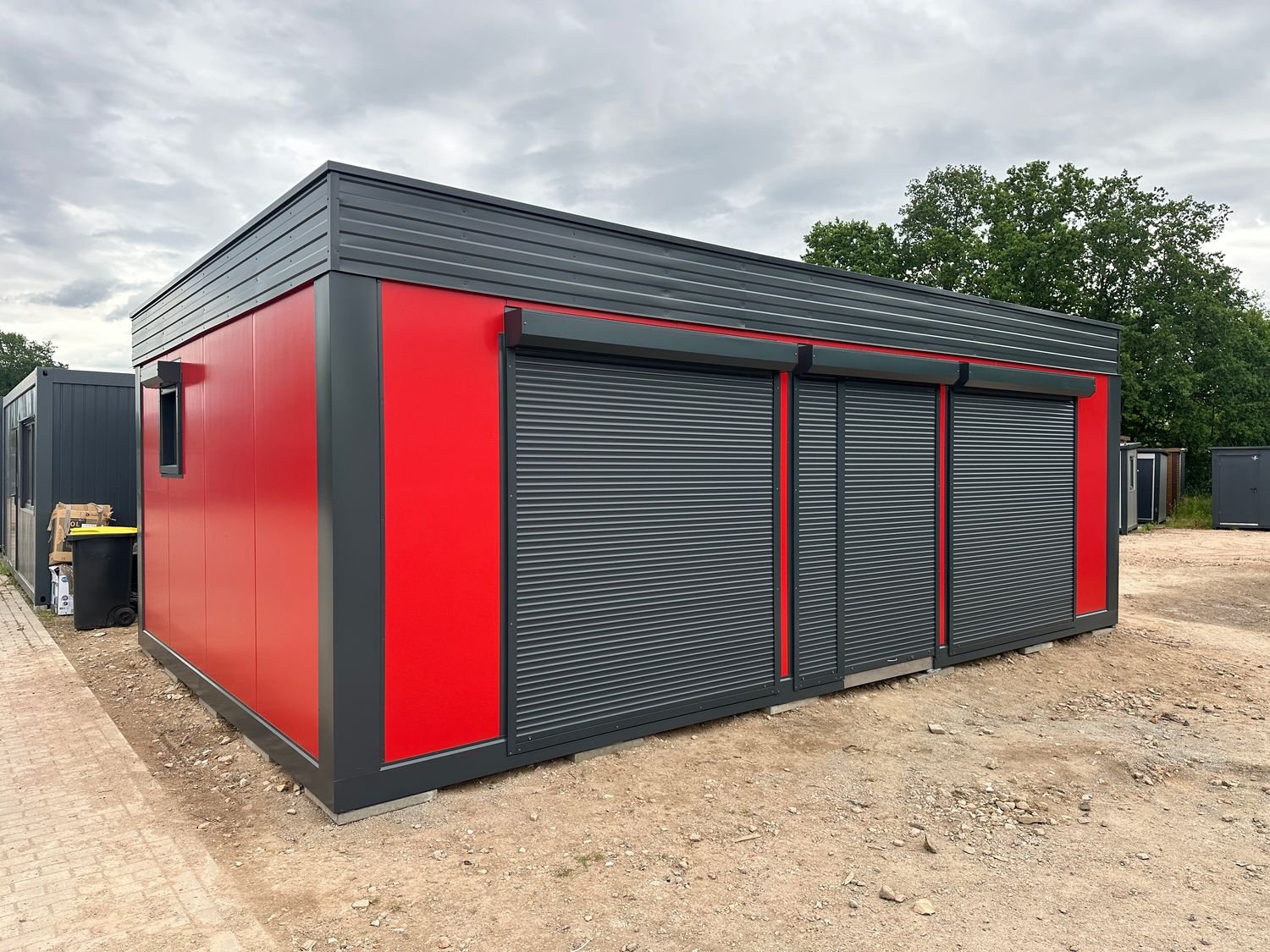 Seitenansicht mit drei geschlossenen Rollläden und rotem Wandpaneel am Imbisscontainer 5,00 x 8,00