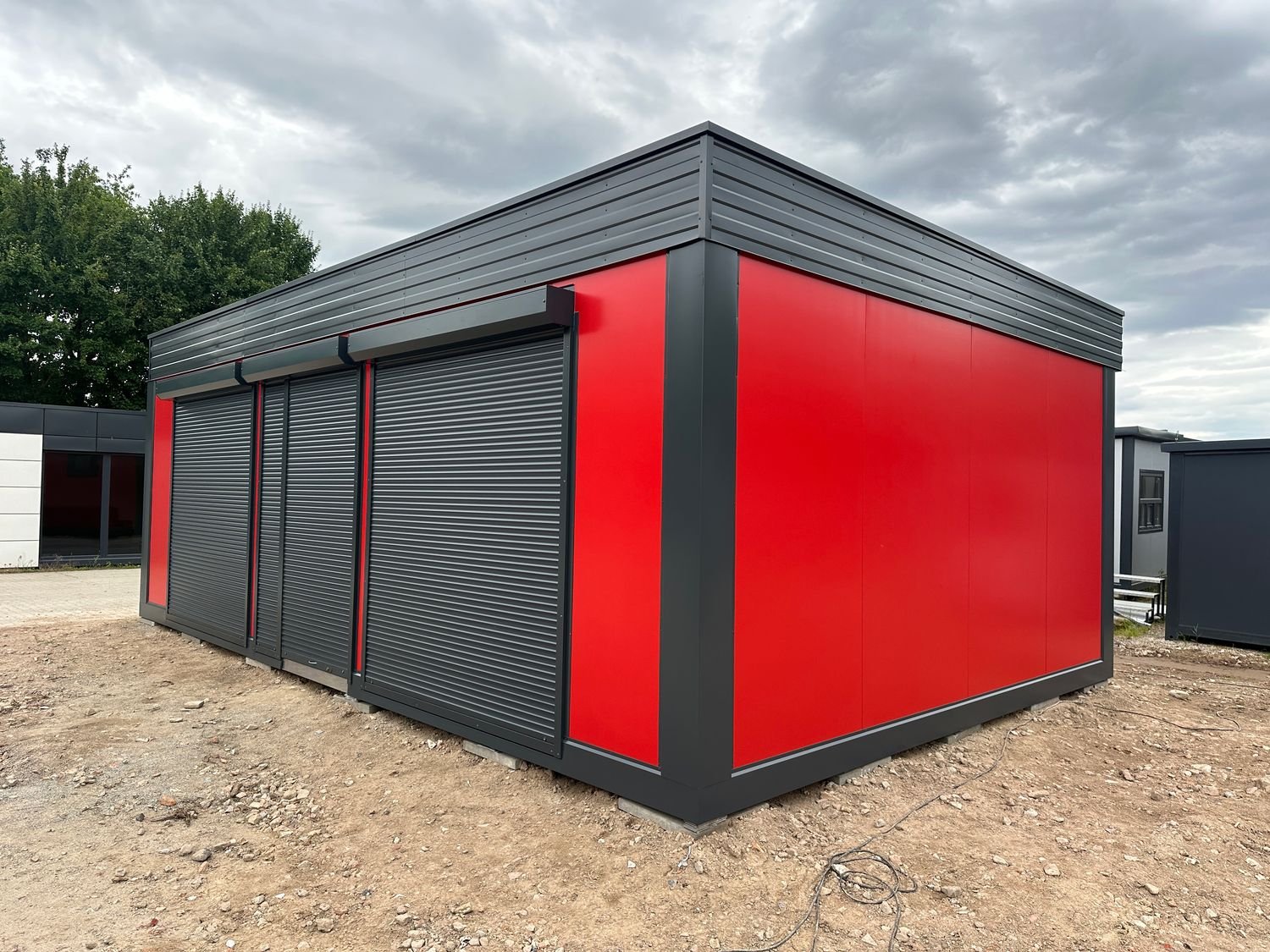 Eckansicht des Imbisscontainers mit fensterloser roter Rückwand und den geschlossenen Rollläden