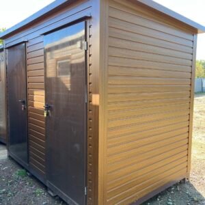 Seitliche Außenansicht des Doppel-WC Containers in Holzoptik mit zwei braunen Türen auf Kiesuntergrund