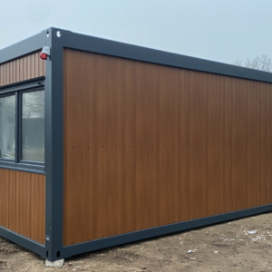 Außenansicht mit fensterloser Längsseite und Eckfenster am Bürocontainer mit stirnseitiger Tür