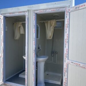 Beide Türen des Sanitärcontainers geöffnet: Waschbecken, Duschvorhänge, Duschwannen, Rahmen mit Schutzfolie