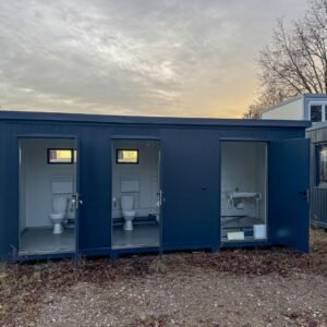 Frontansicht des dunkelblauen Sanitärcontainers 6,00 x 2,00 m mit drei offenen Türen und Einblick